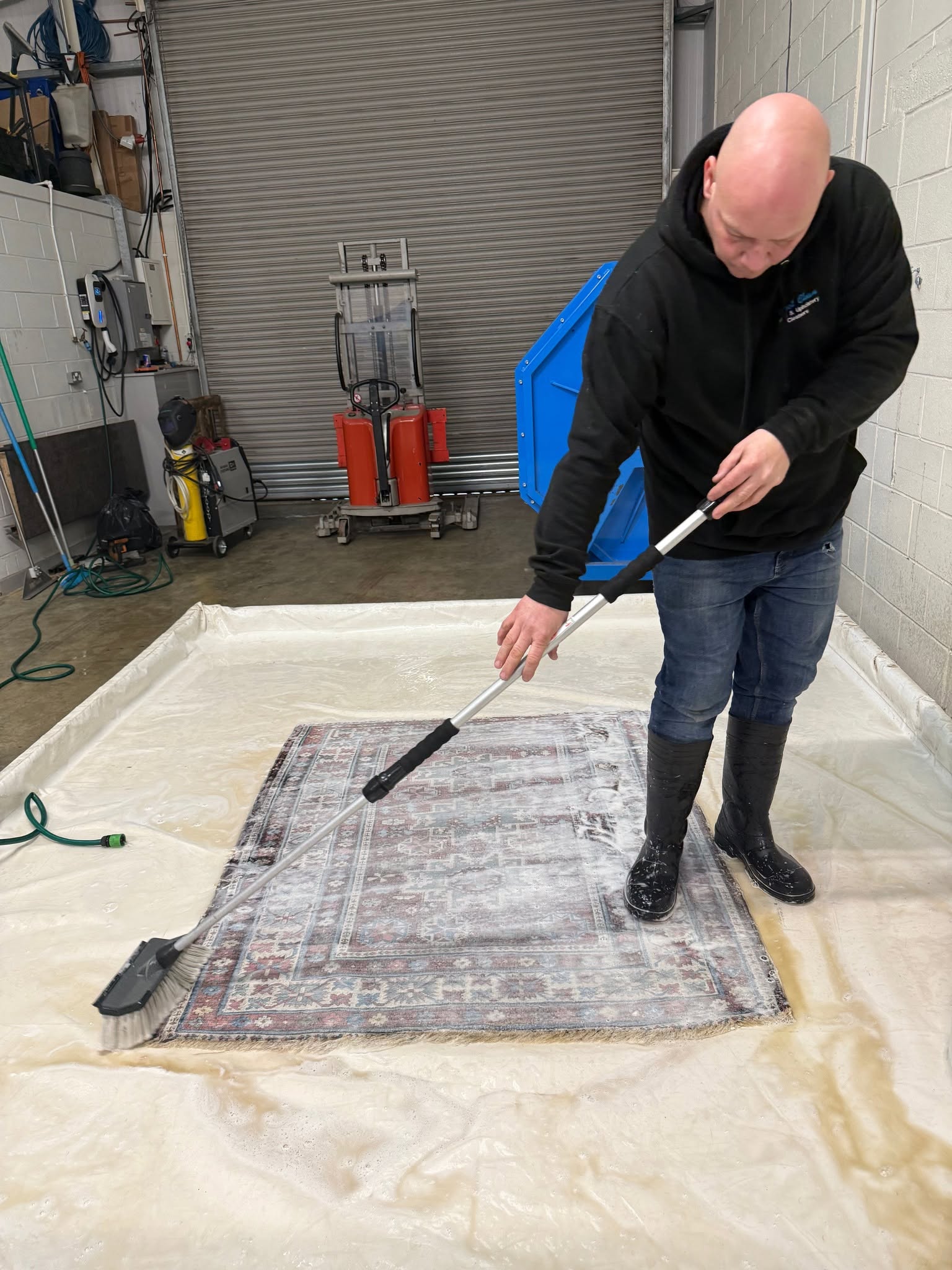 Rug Cleaner Scotland washing a patterned rug by hand at its Milngavie workshop